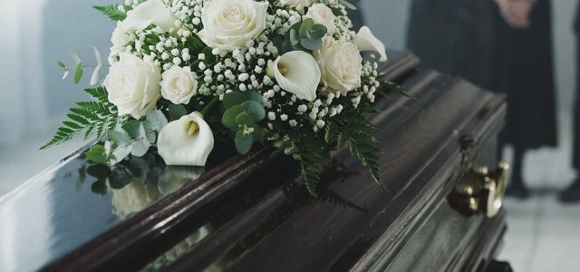 Trumna przybrana białymi kwiatami przygotowana do ceremonii pogrzebowej